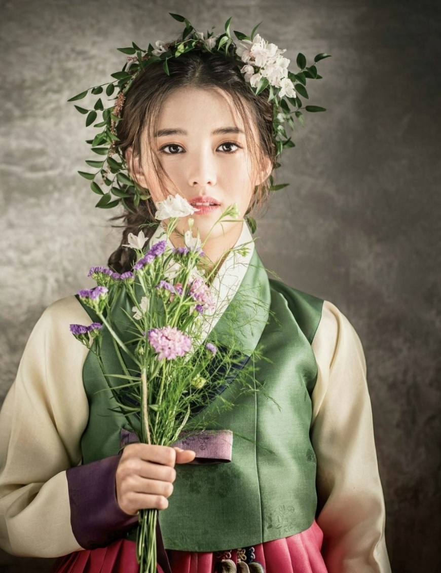 Model with green Hanbok and flowers in her right hand